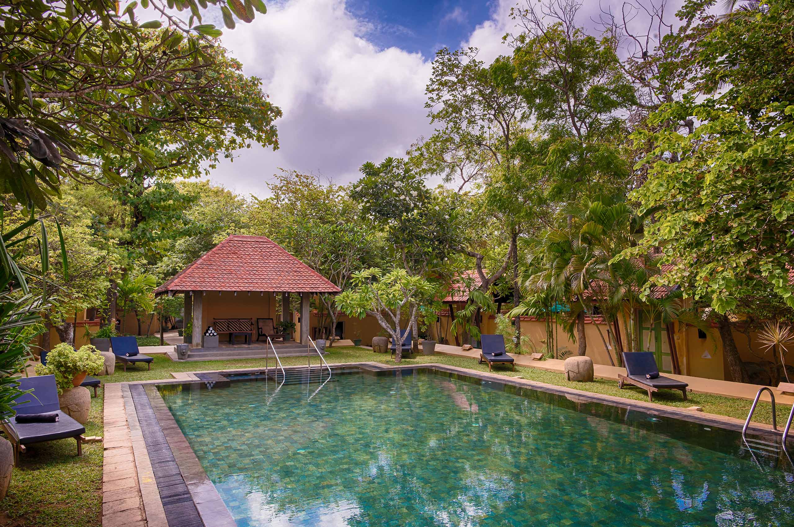 Swimming pool surrounded by tropical gardens at Jetwing Ayurveda Pavilions, Negombo